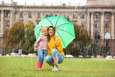 Photo of Happy mother and daughter with umbrella in park