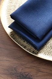 Tray with blue kitchen napkins on wooden table. Space for text