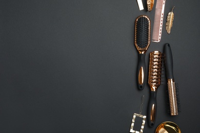 Photo of Flat lay composition with modern hair brushes on black background. Space for text