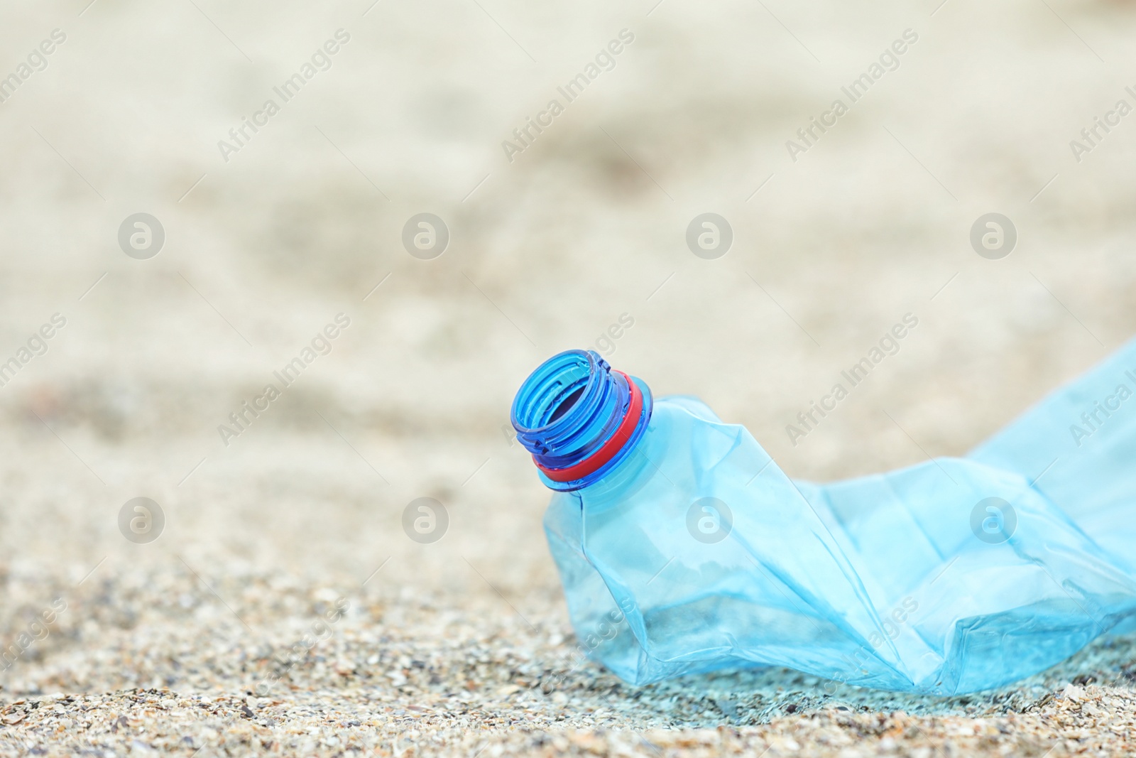 Photo of Used plastic bottle on beach, closeup with space for text. Recycling problem