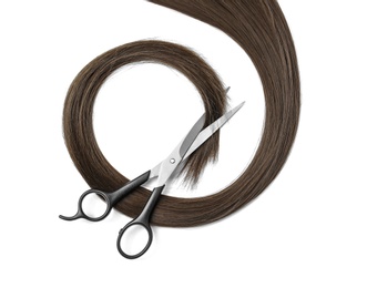 Photo of Brown hair and scissors on white background, top view. Hairdresser service