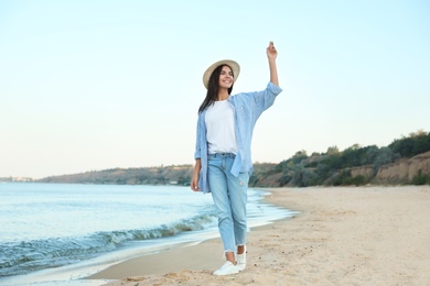 Photo of Beautiful young woman in casual outfit on beach