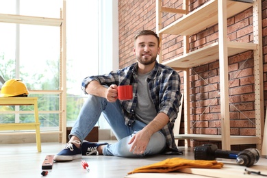 Photo of Young working man having coffee break indoors