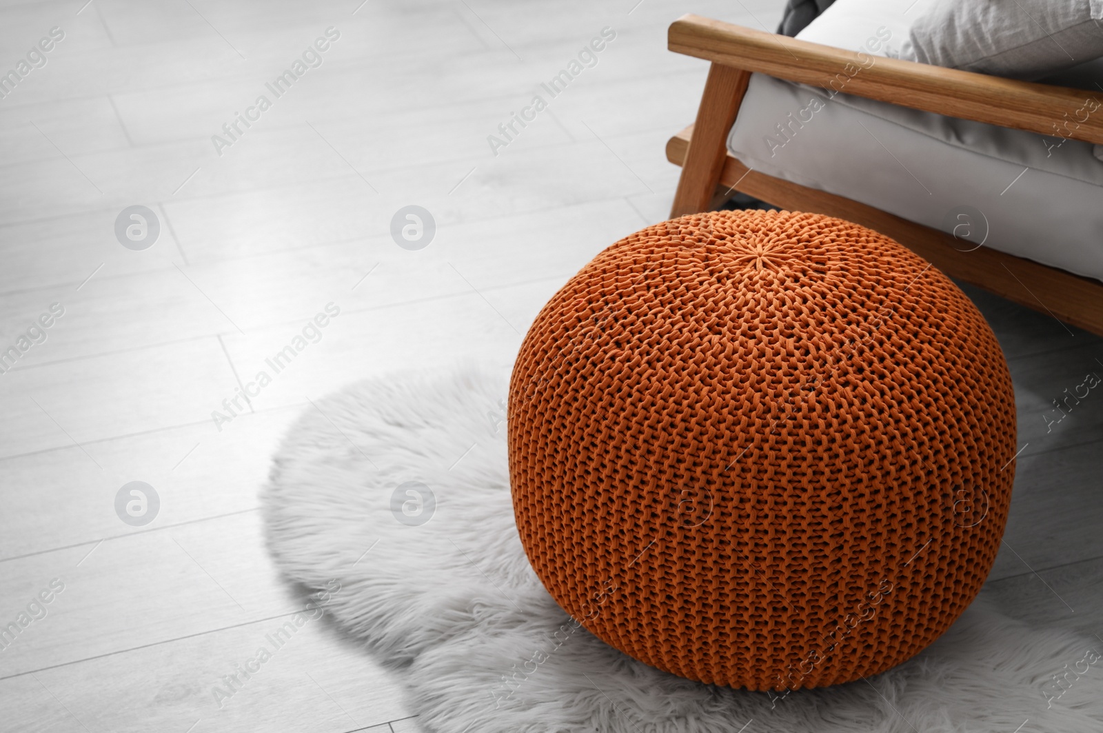 Photo of Stylish knitted pouf on floor in room. Interior design