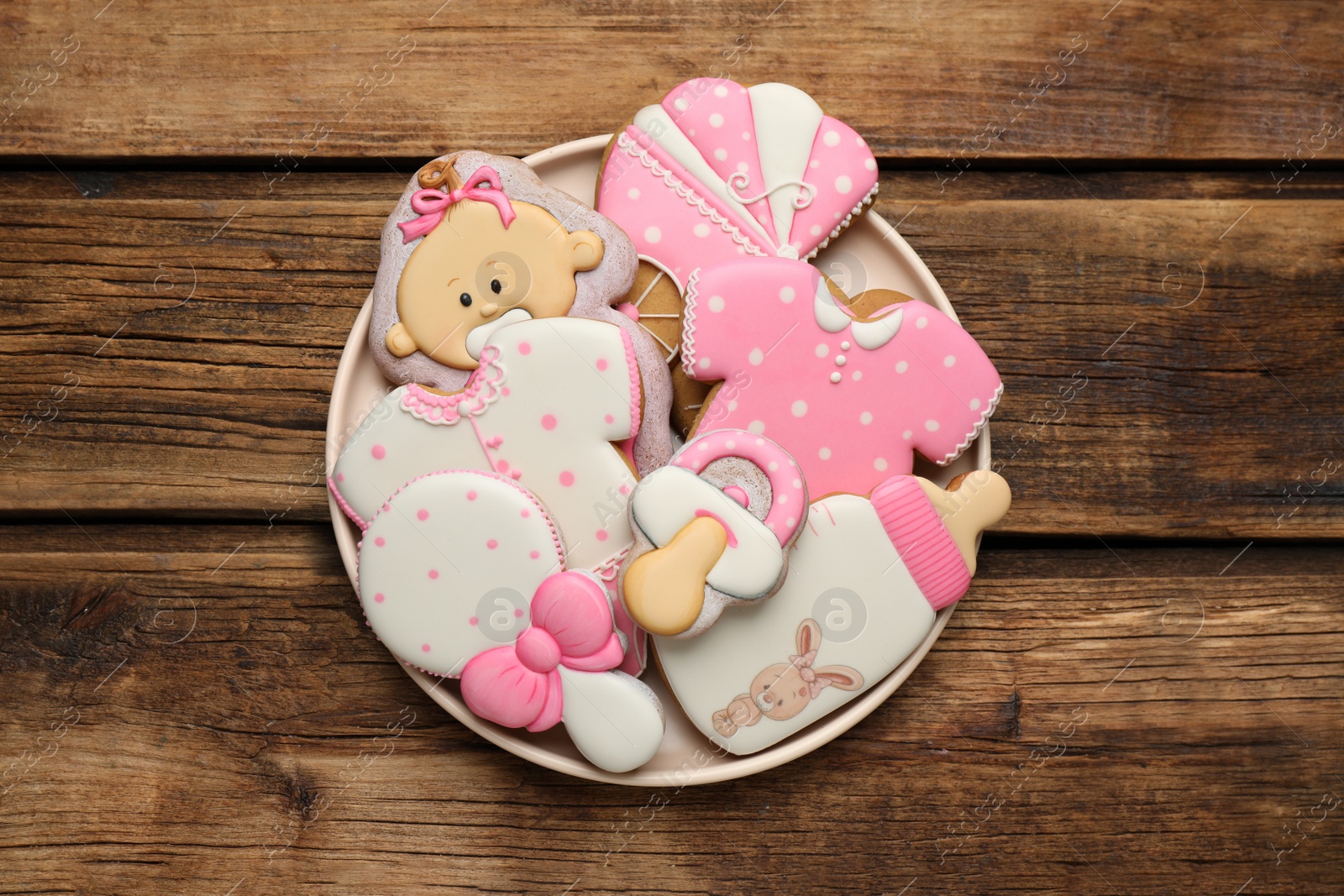 Photo of Cute tasty cookies of different shapes on wooden table, top view. Baby shower party