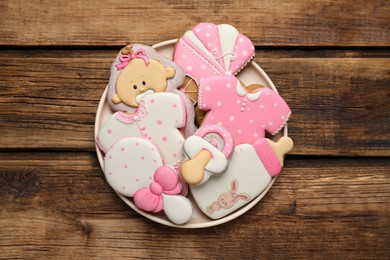 Cute tasty cookies of different shapes on wooden table, top view. Baby shower party