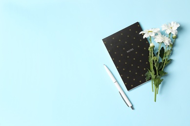 Different school stationery and beautiful white flowers on light blue background, flat lay with space for text. Happy Teacher's Day