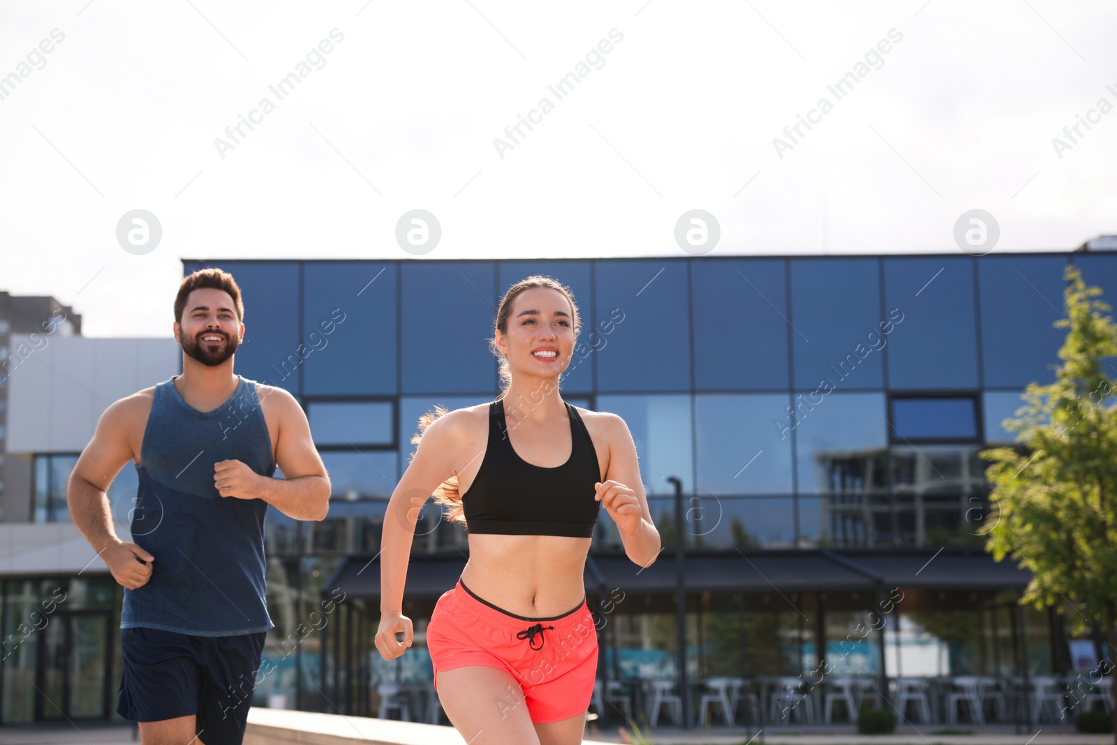 Photo of Healthy lifestyle. Happy couple running outdoors, space for text