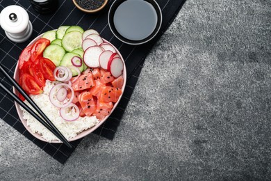 Delicious poke bowl with salmon and vegetables served on grey table, flat lay. Space for text