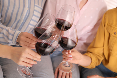 Photo of Young ladies clinking glasses of wine, closeup. Women's Day