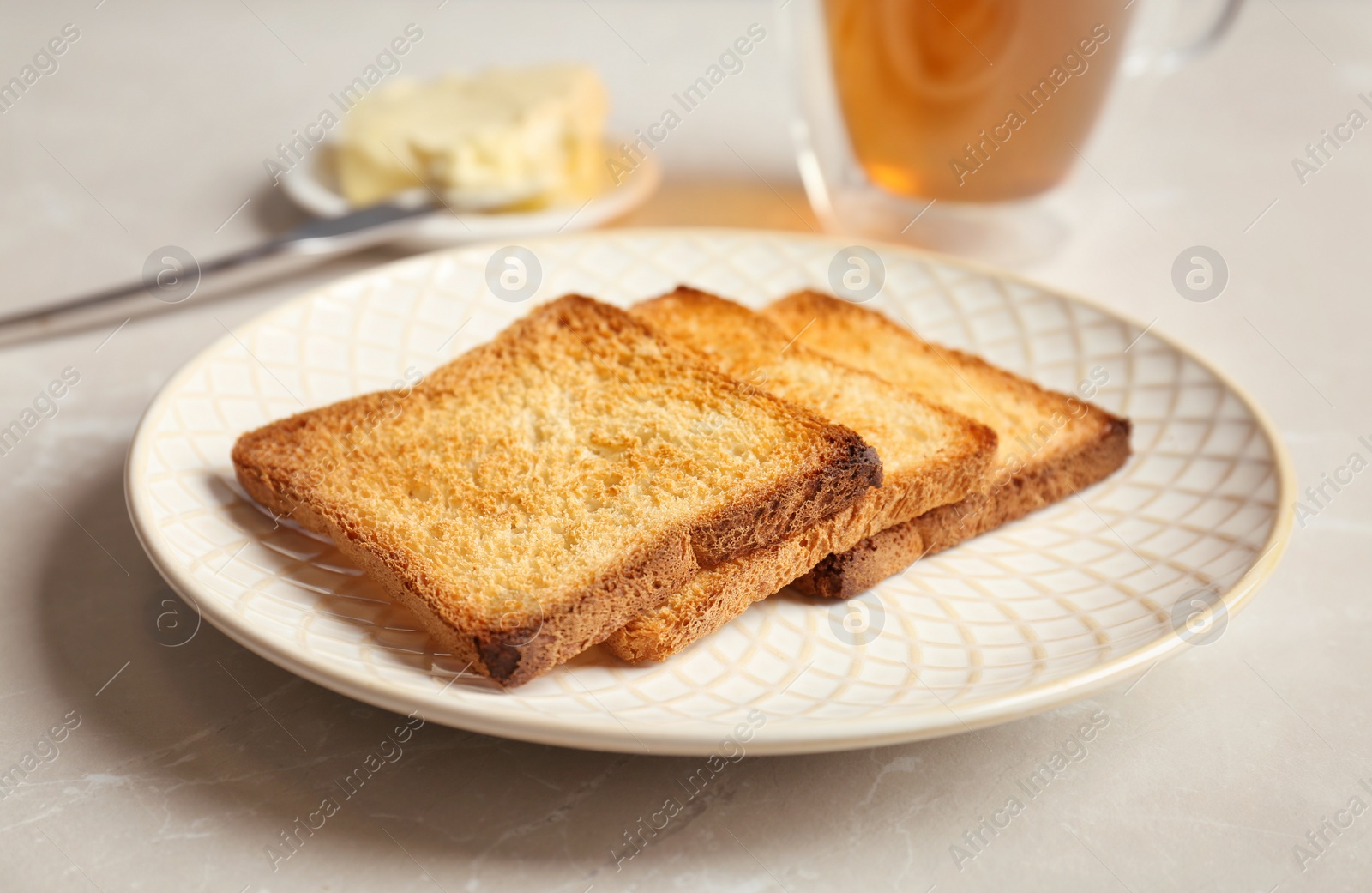 Photo of Plate with toasted bread on table