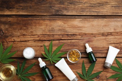 Photo of Composition with CBD oil, THC tincture and hemp leaves on wooden table, flat lay. Space for text