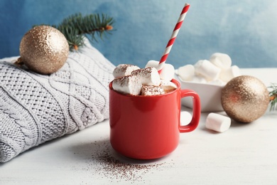 Composition with hot cocoa drink and marshmallows on wooden table