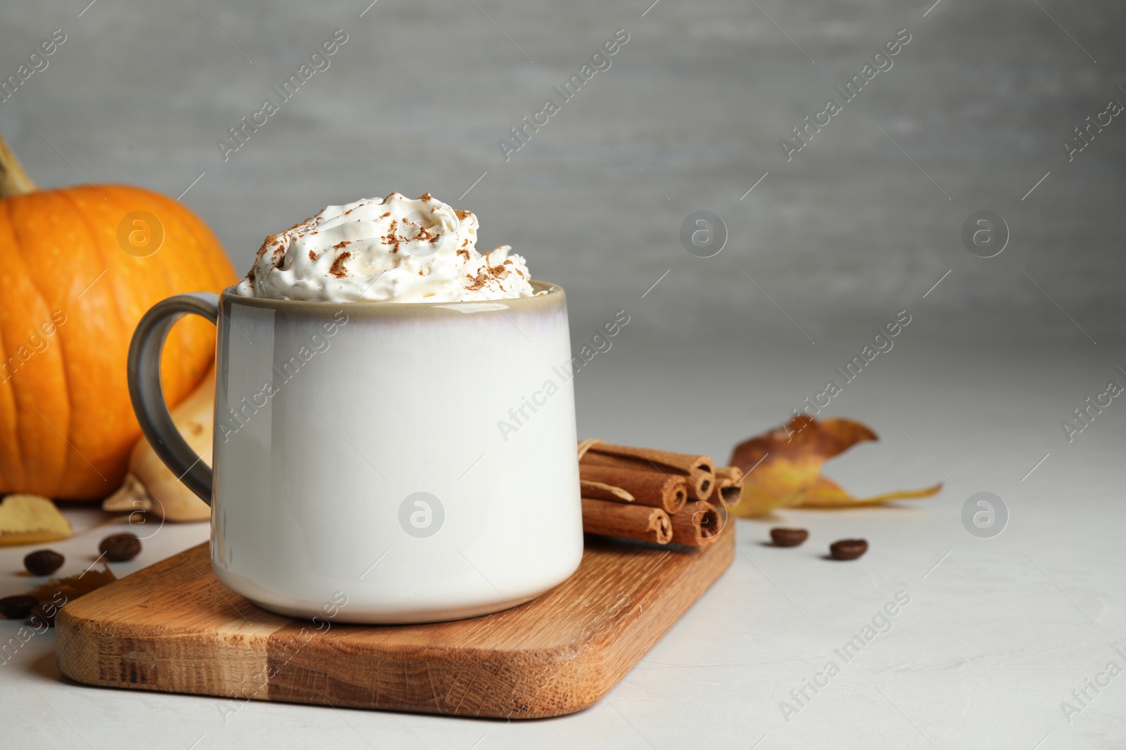 Photo of Cup with tasty pumpkin spice latte on light table, space for text