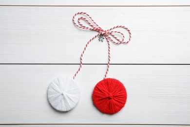 Traditional martisor on white wooden background, top view. Beginning of spring celebration