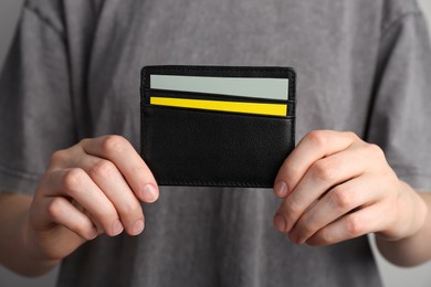 Photo of Woman holding leather business card holder with cards, closeup
