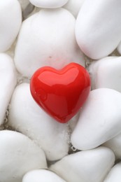 Photo of Red decorative heart on stones and water, top view