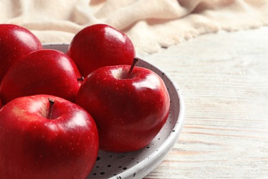 Photo of Plate with ripe red apples on wooden background