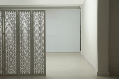 Empty office corridor with white walls and wooden floor