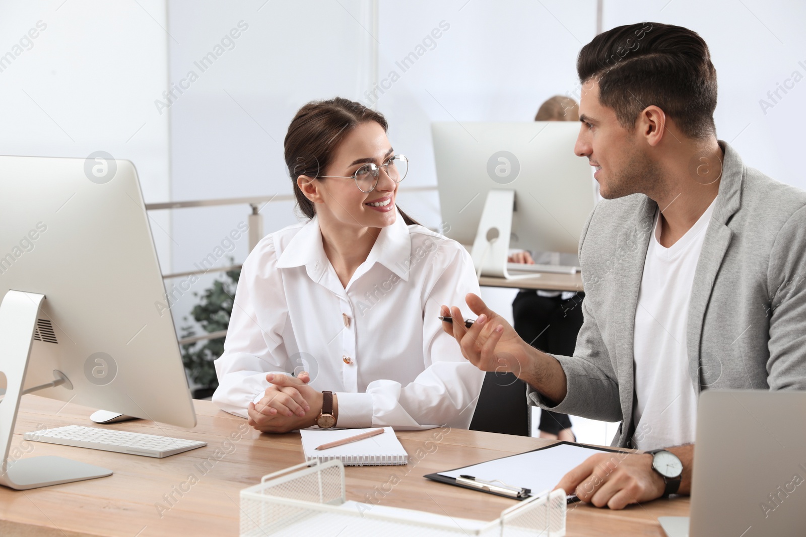 Photo of Businessman helping intern with work in office