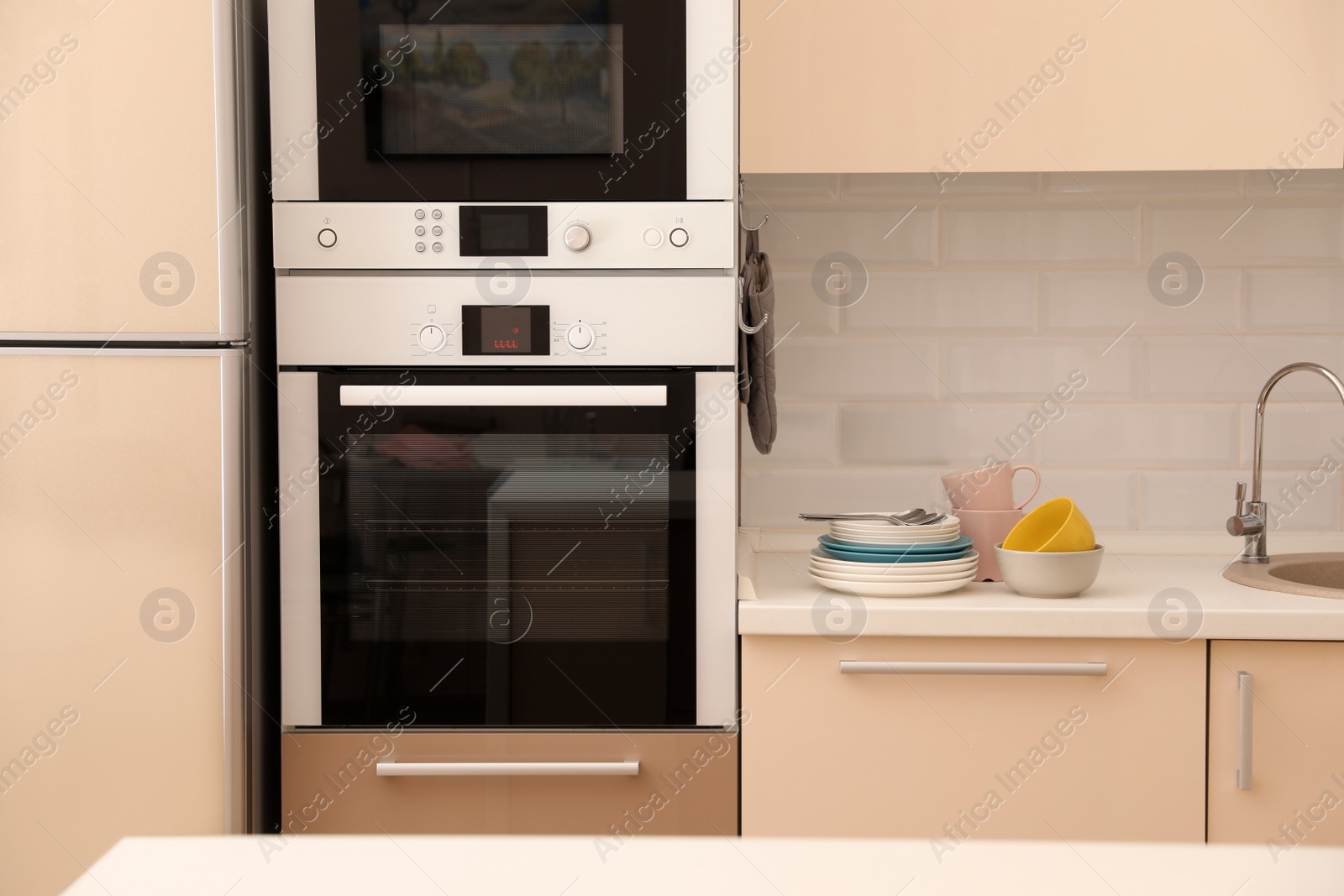 Photo of Clean dishware and cutlery on counter in kitchen