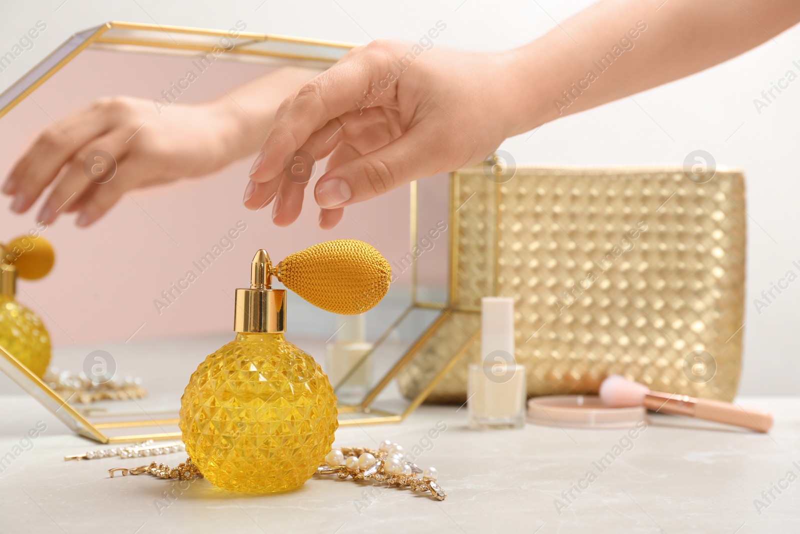 Photo of Woman taking crystal bottle of luxurious perfume from dressing table, closeup. Space for text