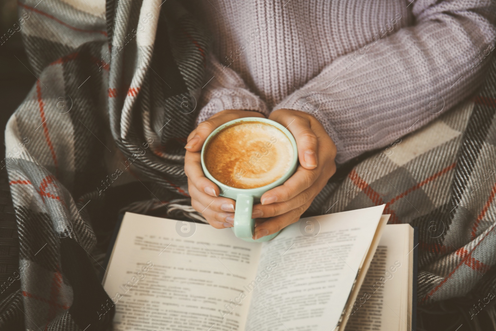 Image of Woman with cup of coffee reading book at home, closeup