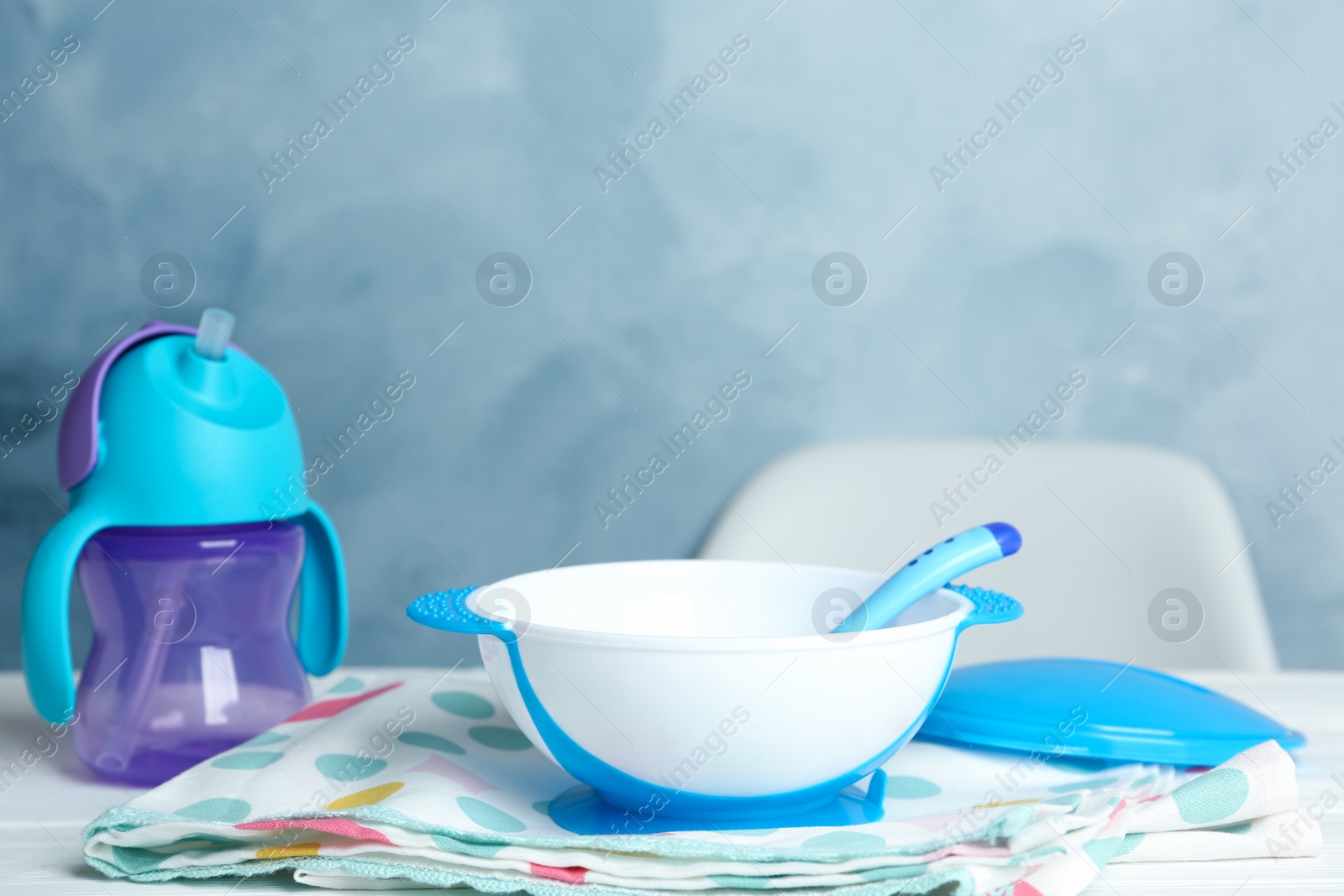 Photo of Set of plastic dishware on white table. Serving baby food