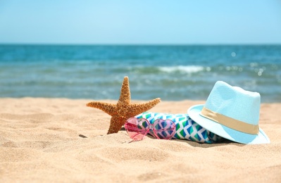 Photo of Set of different beach objects on sand near sea. Space for text