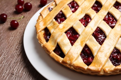 Photo of Delicious fresh cherry pie on wooden table, closeup