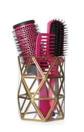 Photo of Hairbrushes and comb in holder on white background