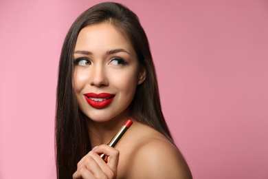 Photo of Beautiful woman with red lipstick on pink background