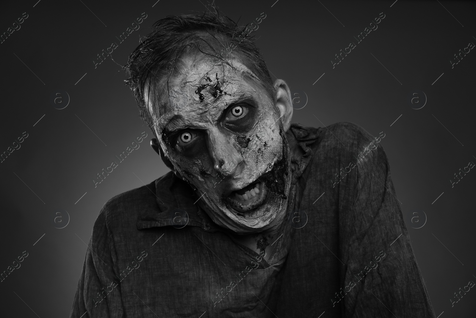 Photo of Scary zombie on dark background, black and white effect. Halloween monster