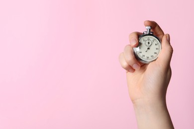 Photo of Woman holding vintage timer on pink background, closeup. Space for text