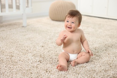 Photo of Cute baby boy sitting on carpet at home. Space for text