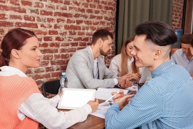 Photo of Team of employees working together in office