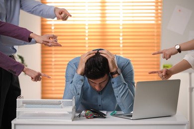 Photo of Coworkers bullying their colleague at workplace in office