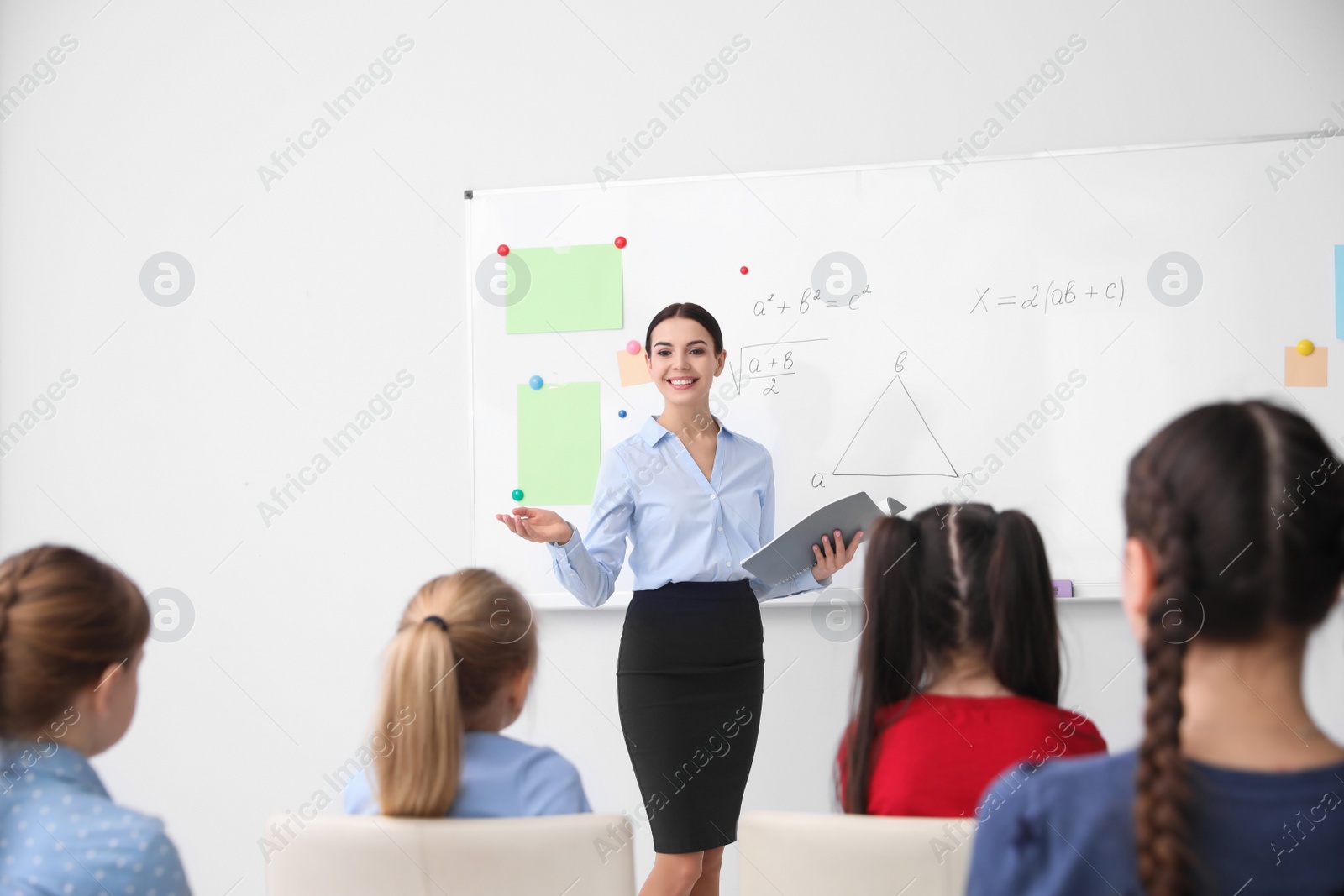 Photo of Young teacher and students in modern classroom