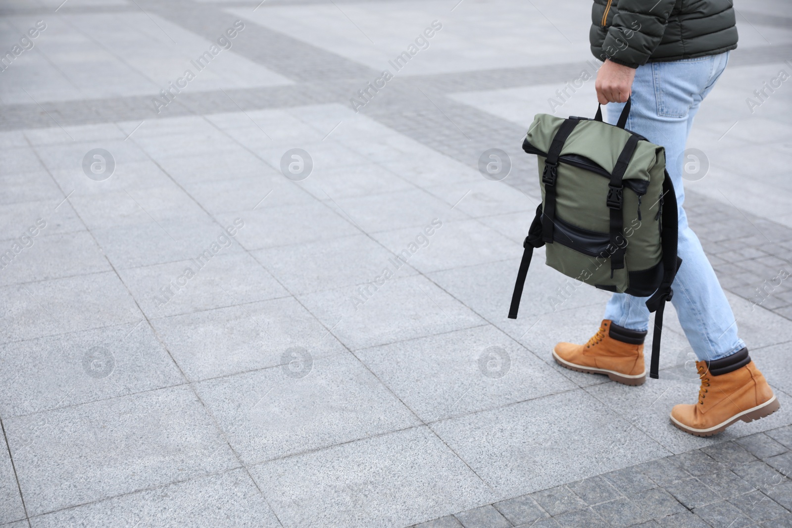 Photo of Male tourist with travel backpack on city street, closeup. Urban trip