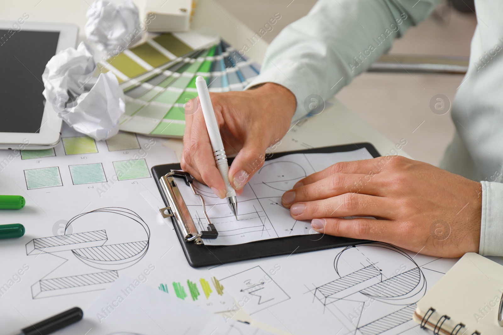 Photo of Male designer working at white table, closeup