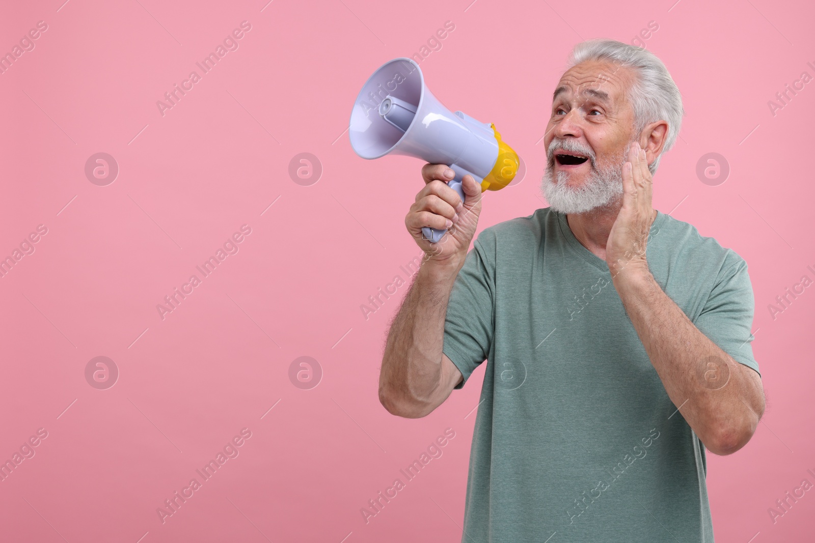 Photo of Special promotion. Senior man shouting in megaphone on pink background. Space for text