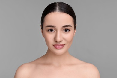 Portrait of beautiful young woman on grey background