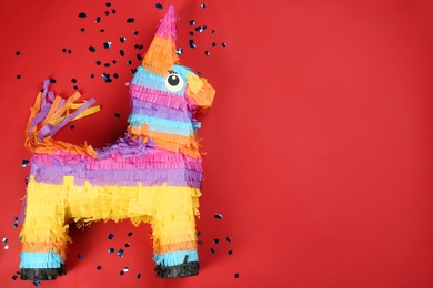 Photo of Bright donkey pinata and confetti on background, flat lay. Space for text