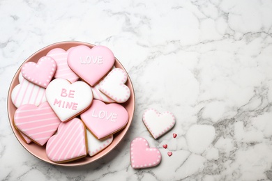 Photo of Valentine's day cookies on white marble table, flat lay. Space for text