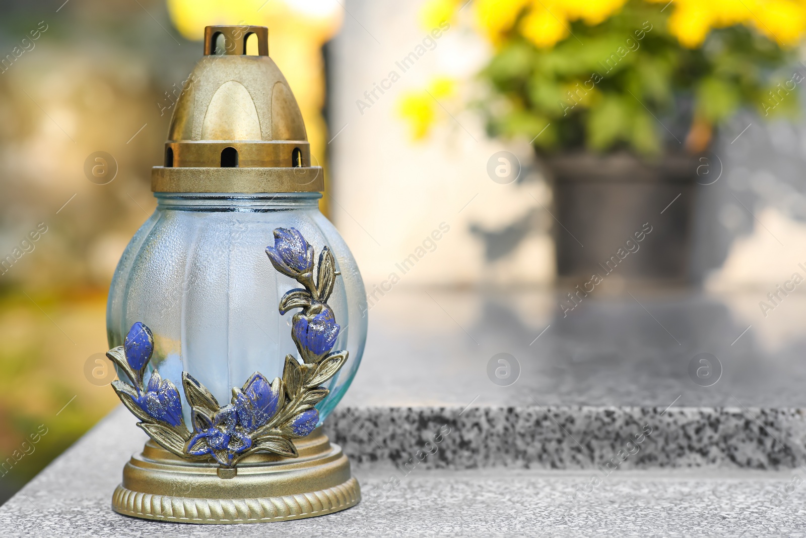 Photo of Grave lantern on granite surface in cemetery, space for text