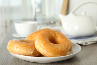 Photo of Sweet delicious glazed donuts on wooden table