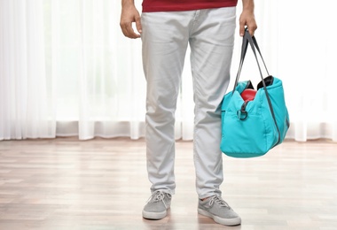 Photo of Young man with sports bag in room