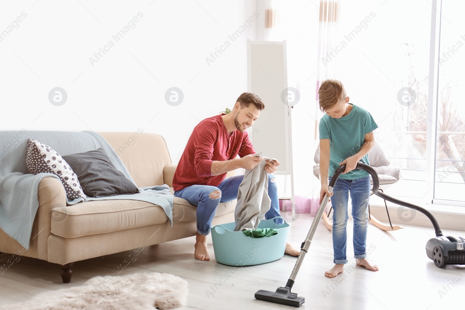 Photo of Little boy and his dad cleaning their house together