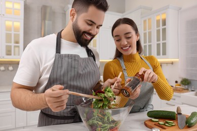 Photo of Lovely young couple cooking together in kitchen