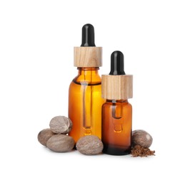 Photo of Bottles of nutmeg oil, nuts and powder on white background